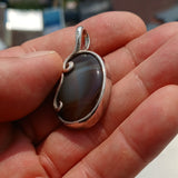 Oval shaped Sterling Silver Artwork Pendant with a black Agate cabochon